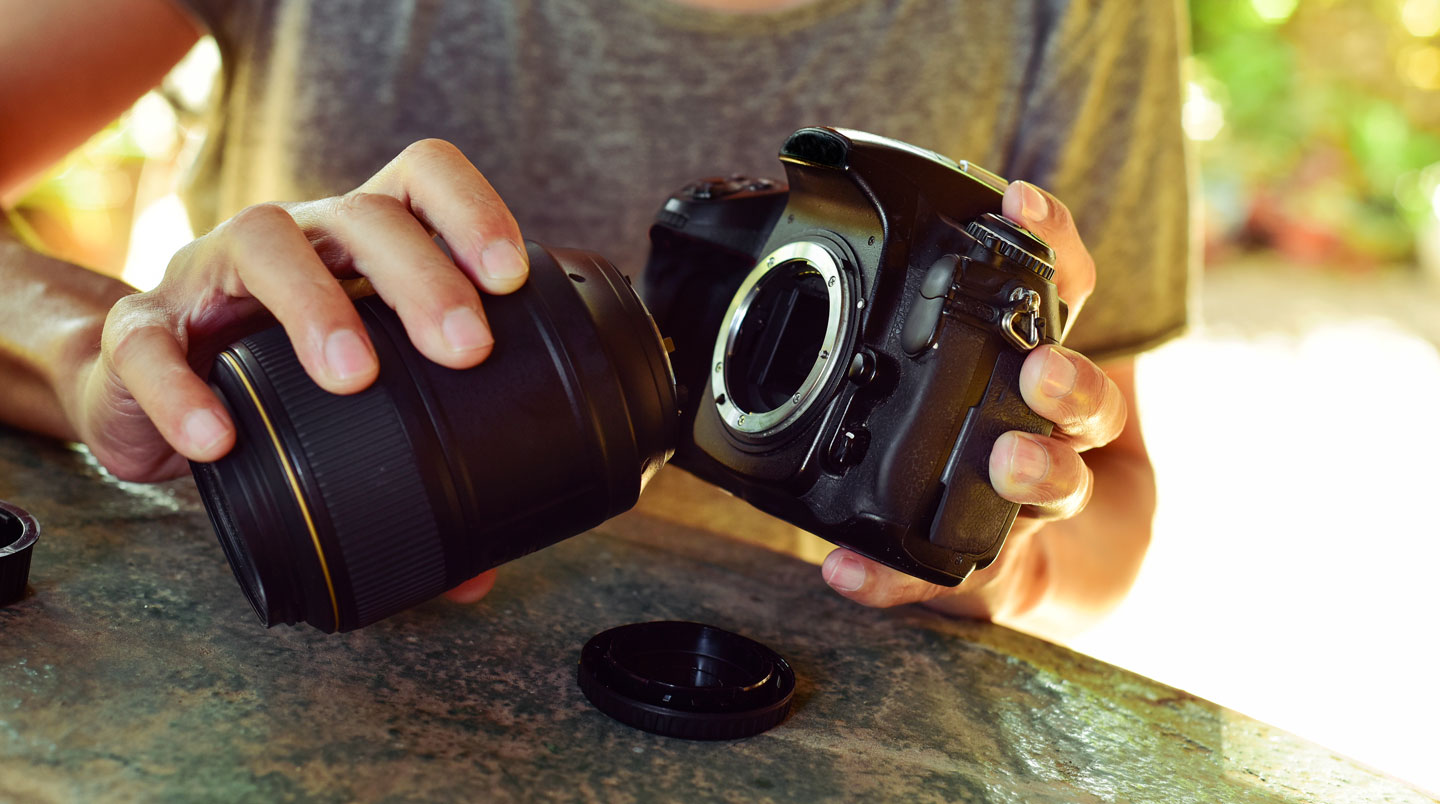 Objectif cinéma sur monture PL posé devant un panneau LED de studio en lumière chaude